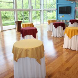 High top tables with maroon and gold tablecloths