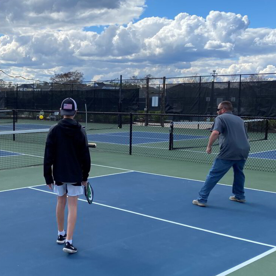 two men are playing tennis on a blue court