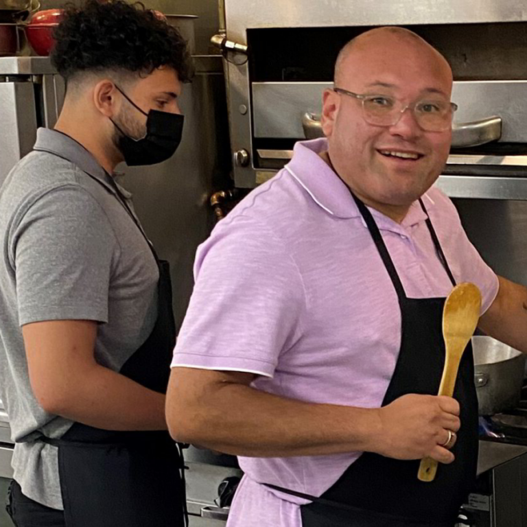 a man wearing a face mask cooking in a kitchen
