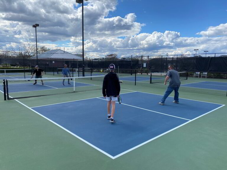 several people playing tennis on a blue and green court