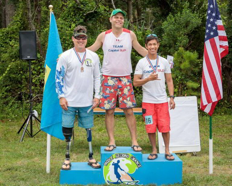 three people standing on a blue podium with two flags