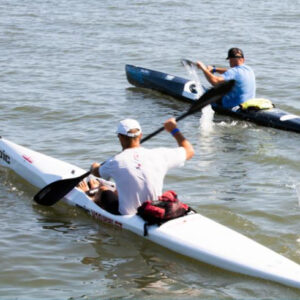 two men are paddling their kayaks in the water