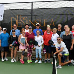 a group of people standing on a tennis court