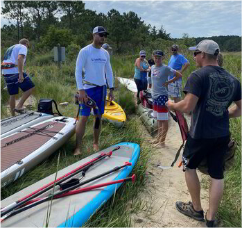 a group of people standing next to some surfboards