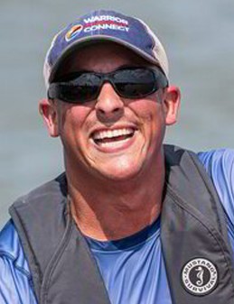 a smiling man wearing sunglasses and a hat