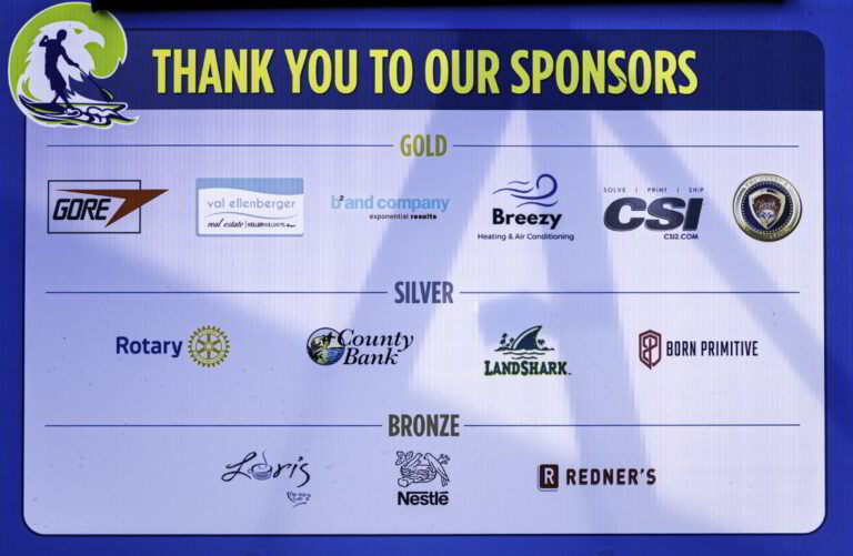 a blue sign with many sponsors on it