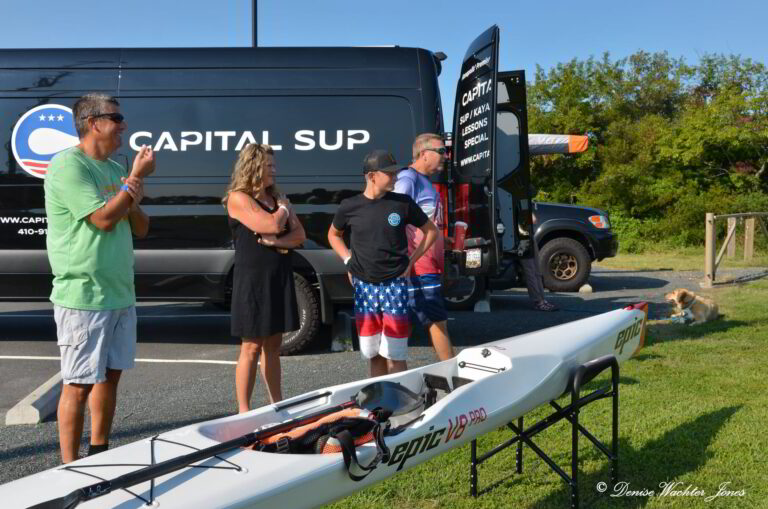 a group of people standing next to a surfboard