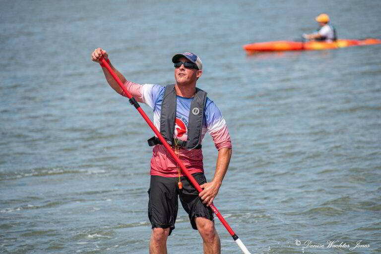 a man standing on a paddle board in the water