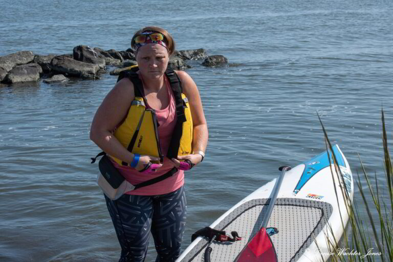 a woman standing next to a surfboard in the water