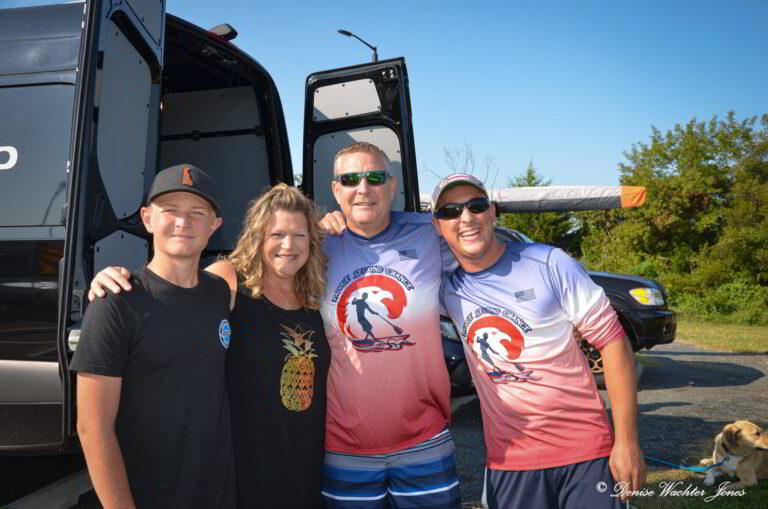 three men and a woman standing in front of a bus