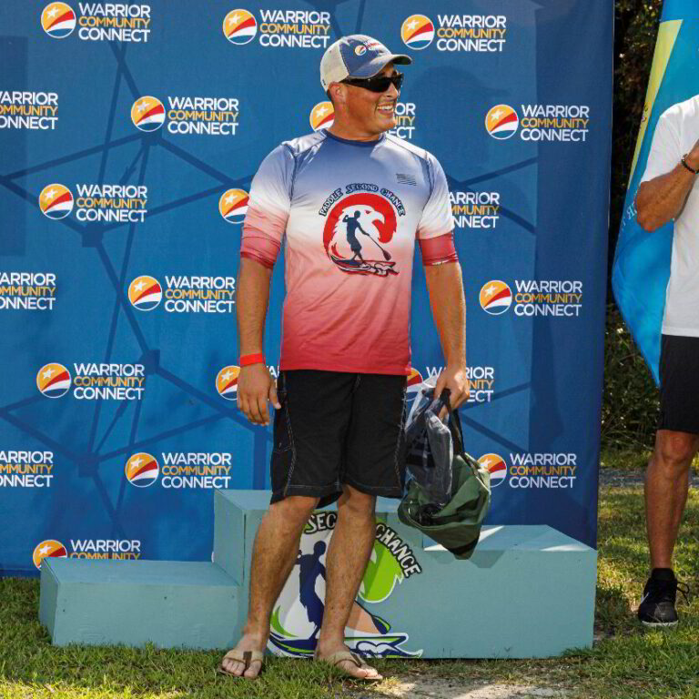 a man standing next to a surfboard in front of a sign