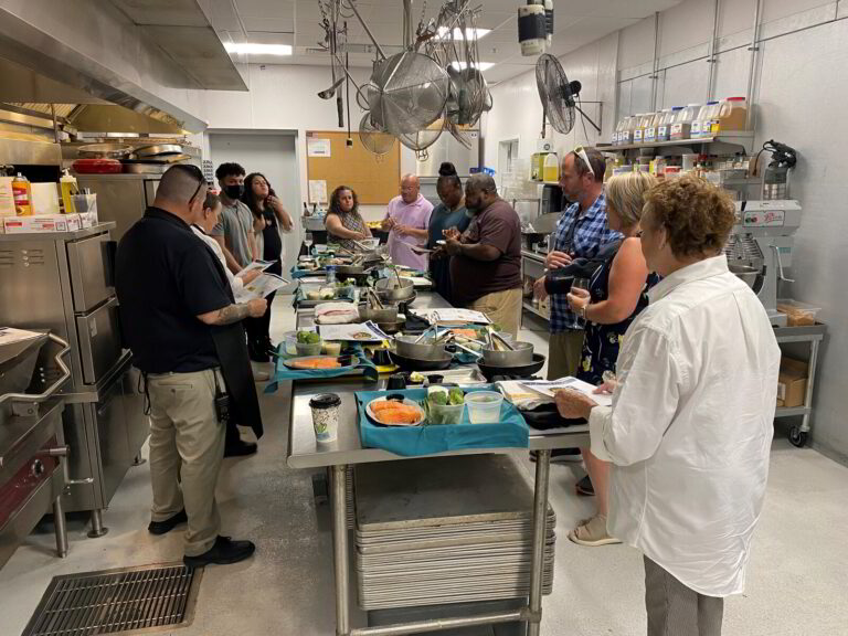 a group of people in a kitchen preparing food