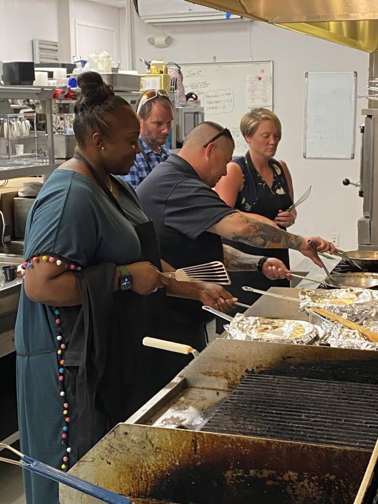 a group of people cooking in a kitchen