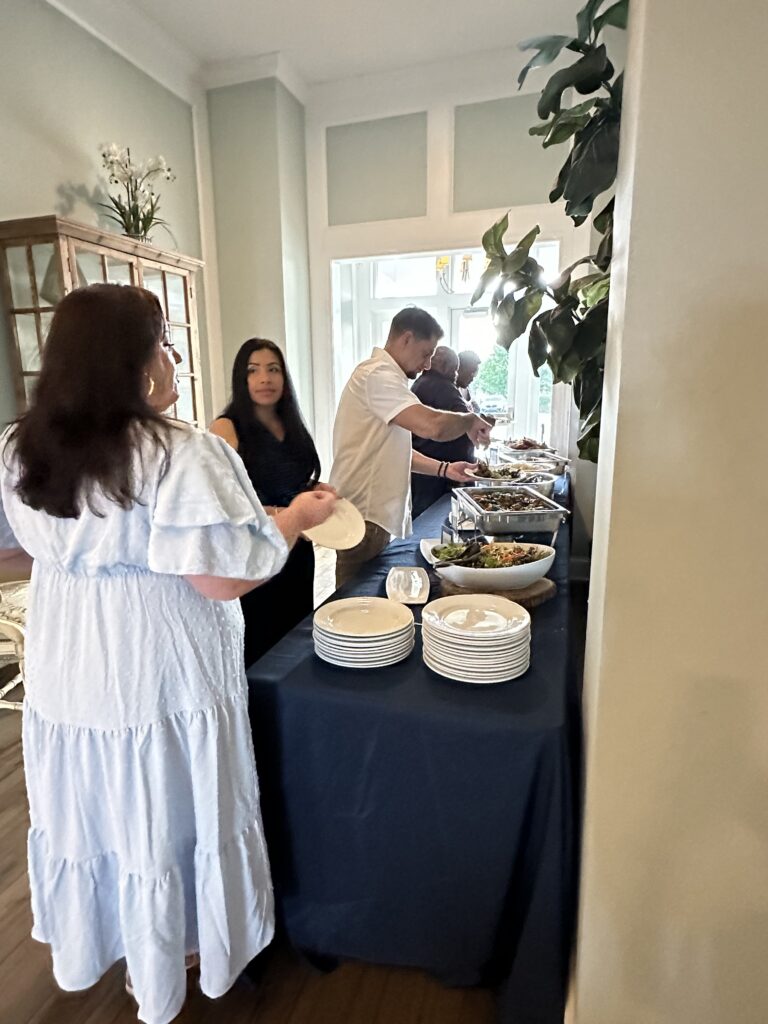 two people standing in front of a table with plates on it