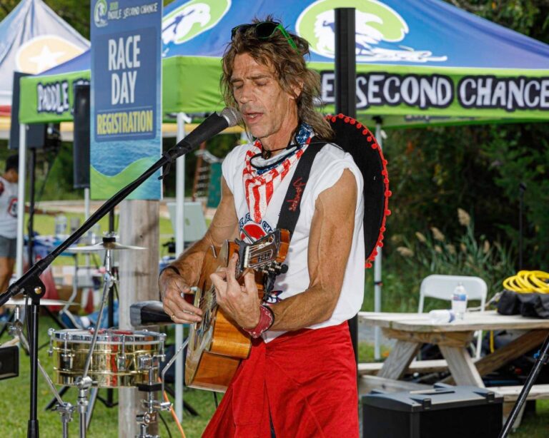 a man with a guitar playing on stage