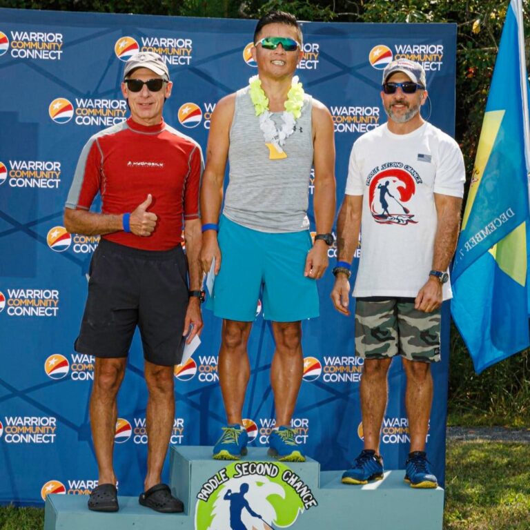three men standing on a podium with one giving the thumbs up