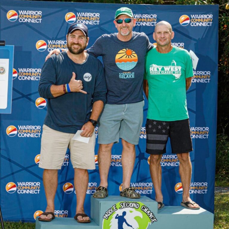 three men standing on a podium giving the thumbs up