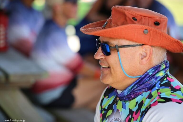 an older man wearing a hat and sunglasses