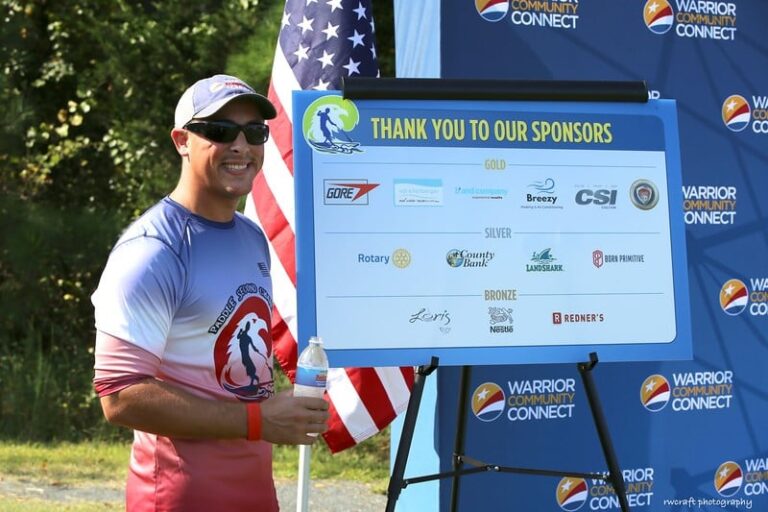 a man standing next to a sign with an american flag
