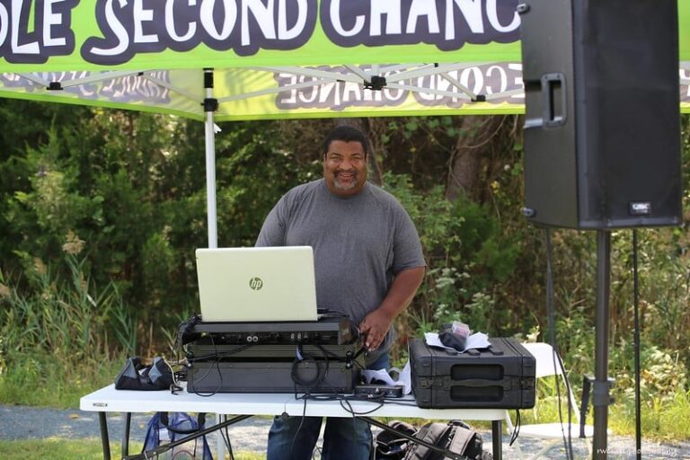 a man standing under a tent with a laptop on it