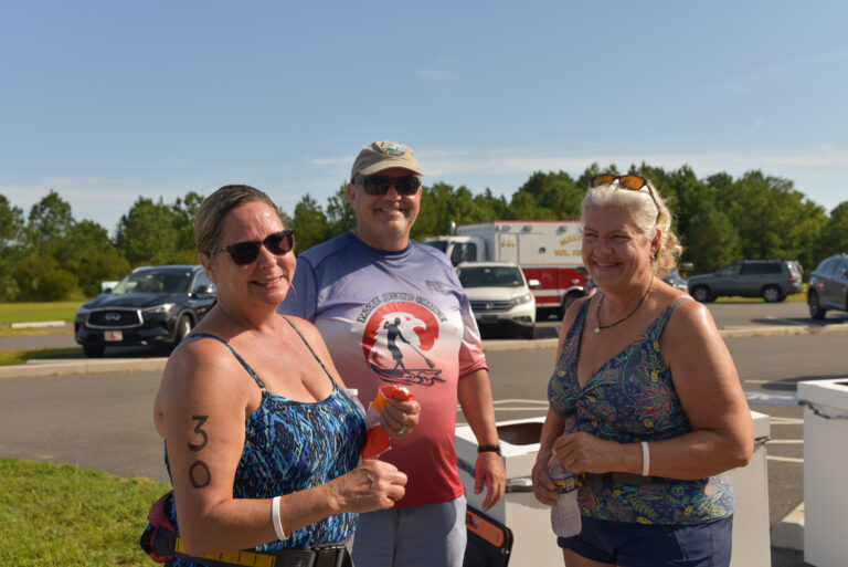 two women and a man standing in front of a parking lot