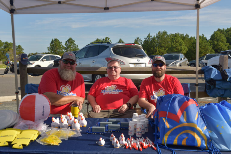 two men in red shirts sitting at a table