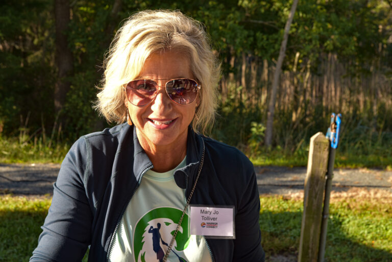 an older woman wearing sunglasses sitting on a bench