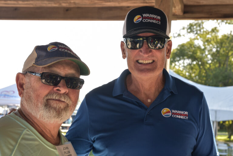two men standing next to each other wearing hats
