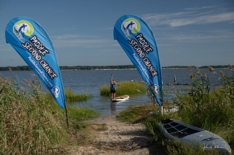 two people stand on surfboards in the water