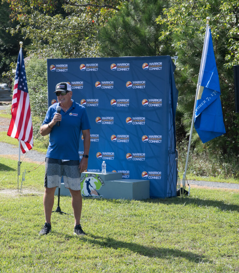 a man standing in the grass with an american flag
