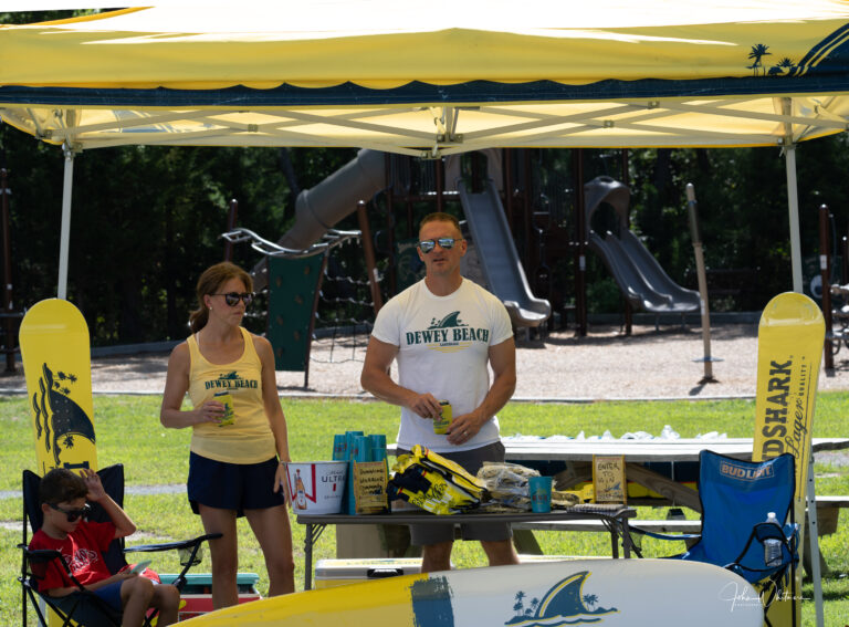 a man and woman standing under a yellow umbrella