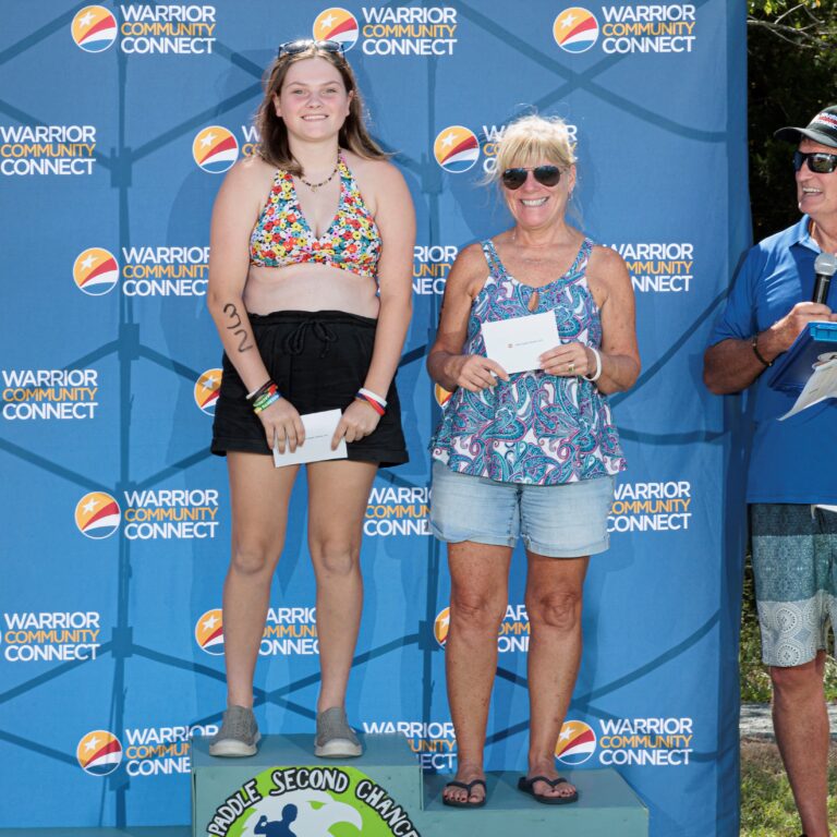 two women standing on top of a podium