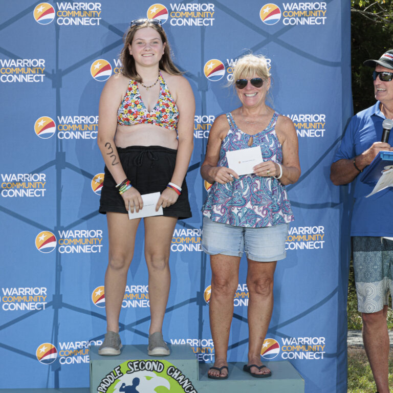 two women standing on top of a podium