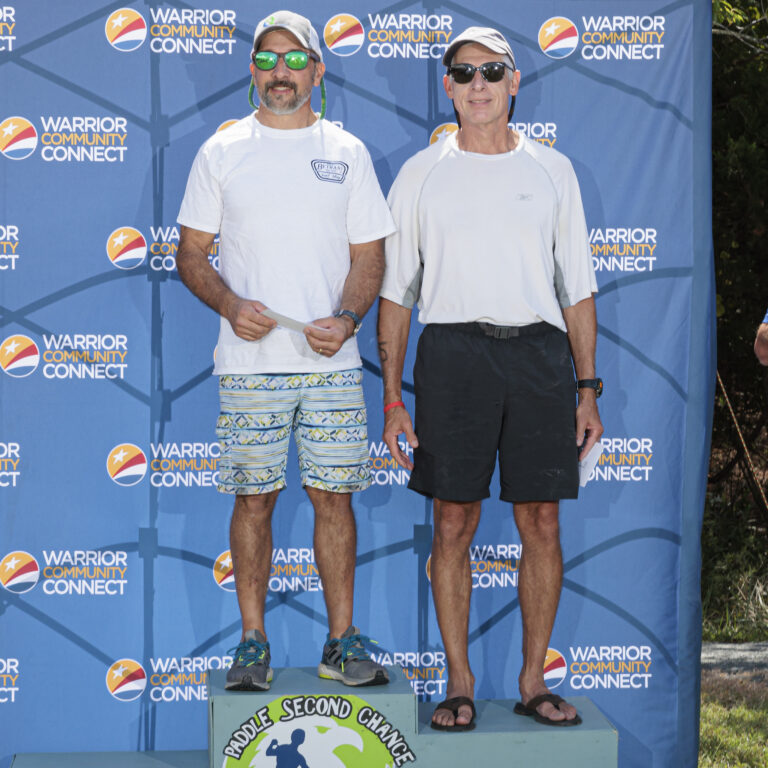 two men standing on top of a podium