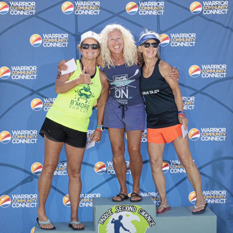 three women standing on top of a podium
