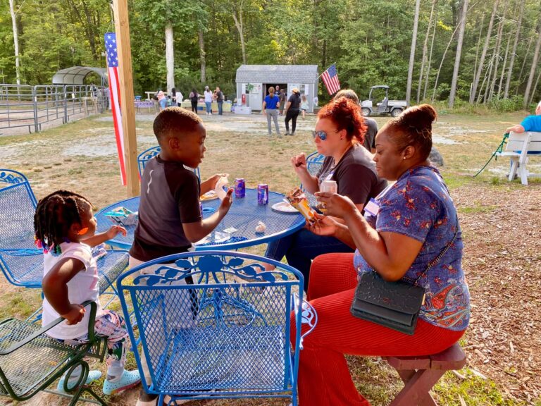 a group of people sitting around a blue table