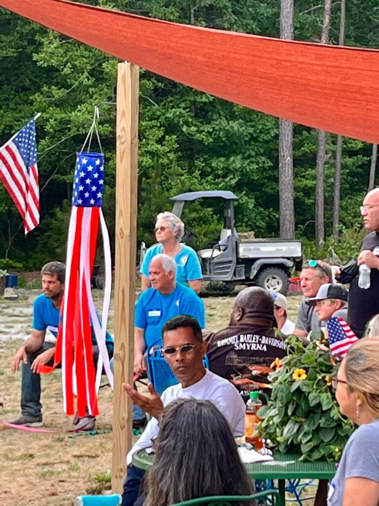 a group of people sitting around a table with american flags