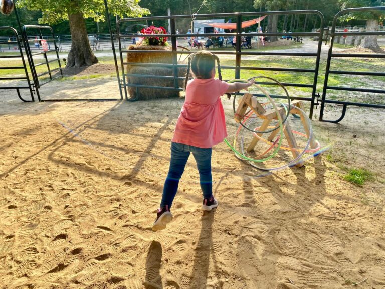 a little girl playing with a toy in the sand