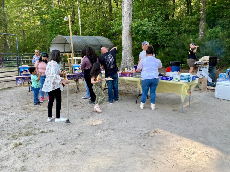 a group of people standing around a picnic table