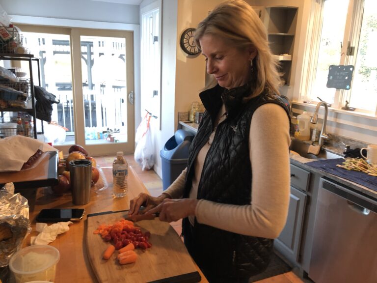 a woman is cutting carrots on a cutting board