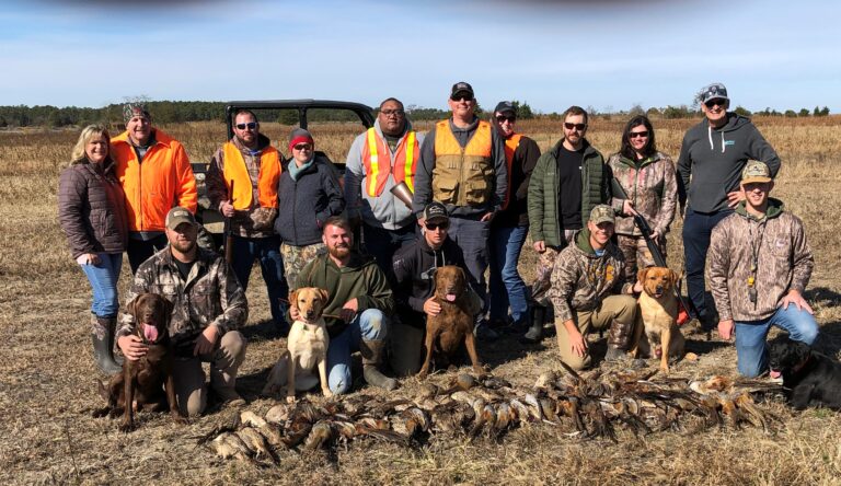 a group of men and women posing with their dogs