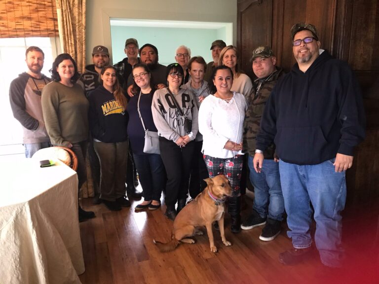 a group of people standing in a room with a dog