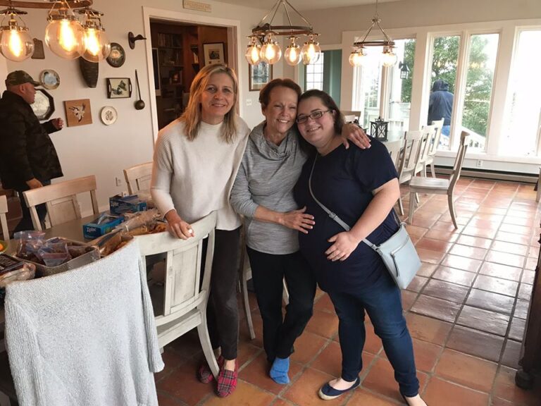 three women are standing in a kitchen posing for the camera