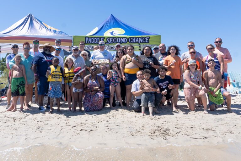a group of people standing on top of a sandy beach