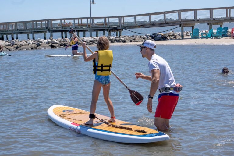 two people standing on surfboards in the water