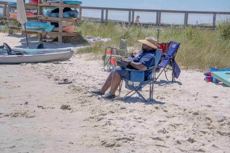 a man sitting in a lawn chair on the beach