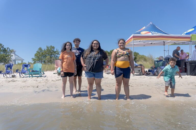 a group of people standing on top of a sandy beach