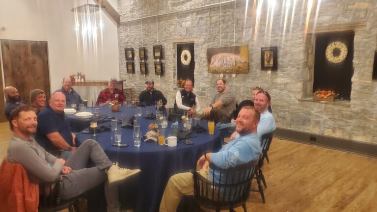 a group of men sitting around a blue table
