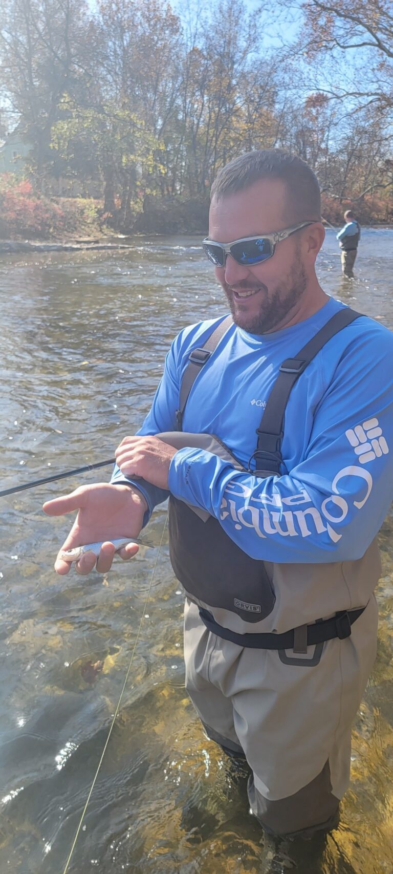 a man standing in the water holding a fish