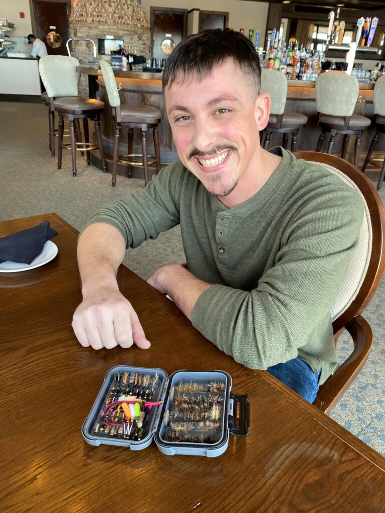 a man sitting at a table with two trays of food